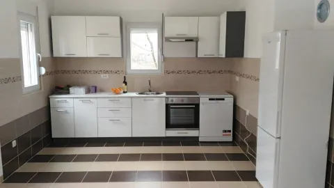 Bright and functional kitchen with white cabinets and built-in appliances. - image 17