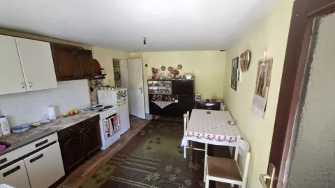 Starija kuhinja sa trpezarijskim stolom i drvenim elementima. - image 15