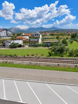 View from the property overlooking the surrounding neighborhood, railway tracks, and mountains in the distance. - image 9
