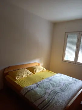 A simply furnished bedroom with a double bed. - image 10