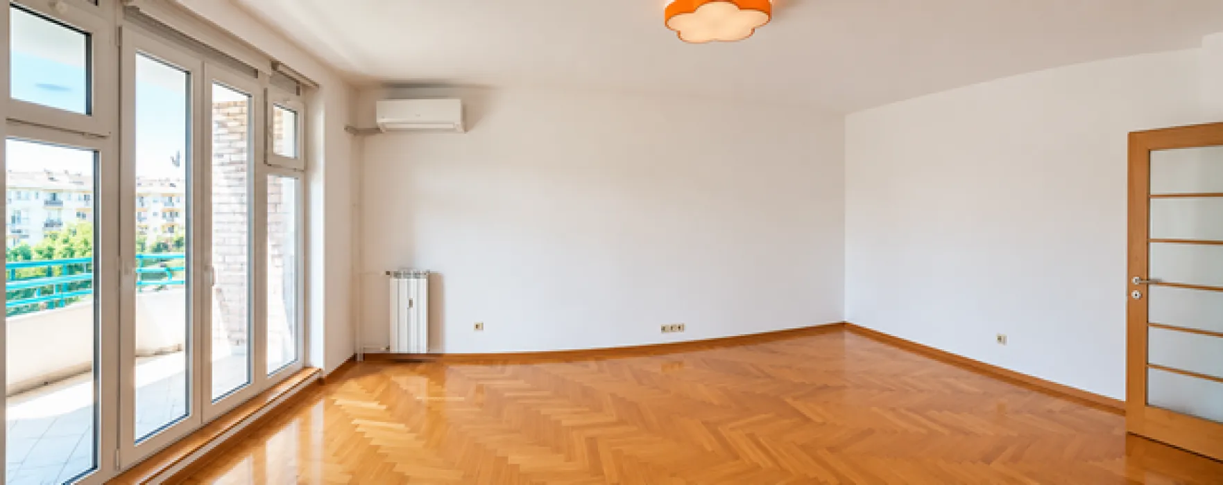 Empty room with parquet flooring and access to the terrace.