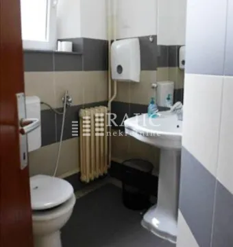 Small bathroom with a sink, toilet, and radiator. - image 4