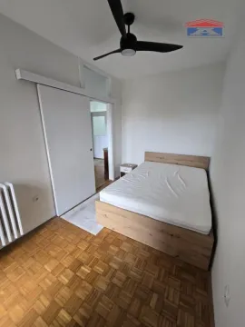 Spavaća soba sa bračnim krevetom, drvenim parketom i plafonskim ventilatorom. - image 10