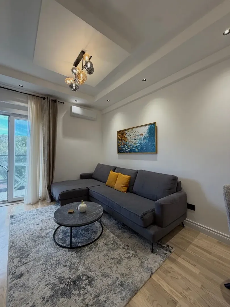 Living room with a sectional sofa, coffee table, and access to the terrace.