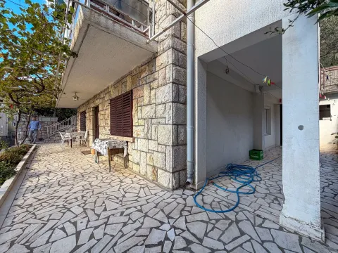 Dvorište sa kamenom fasadom i terasom ispred kuće. - image 7