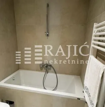 Modern bathroom with a built-in bathtub and shower system. - image 9