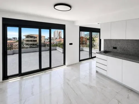 Living room with a kitchen and large glass surfaces leading to the terrace. - image 5