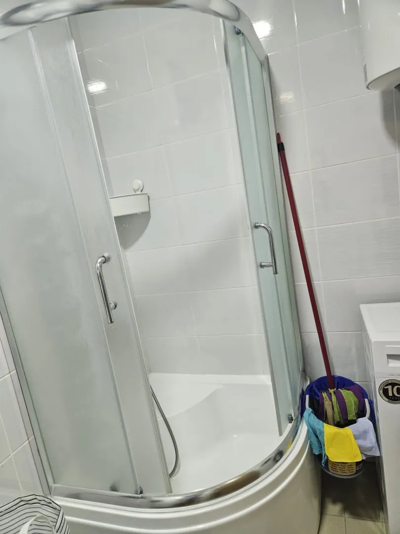 Bathroom with a shower cabin and white tiles.