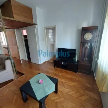Dnevna soba sa drvenim podom, televizorom i starinskim satom. - image 2