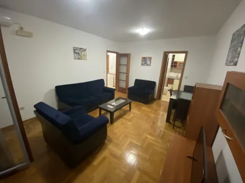 Living room with blue sofas and wooden flooring. - image 3
