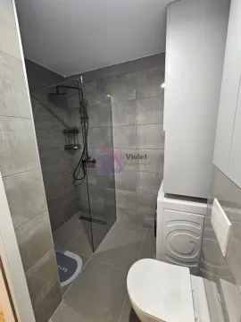 Modernly equipped bathroom with a walk-in shower and washing machine. - image 18