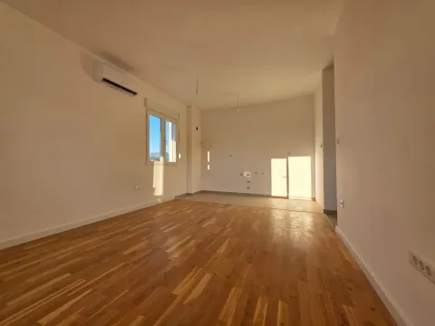 Prazna soba sa drvenim podom i klima uređajem na zidu. - image 2