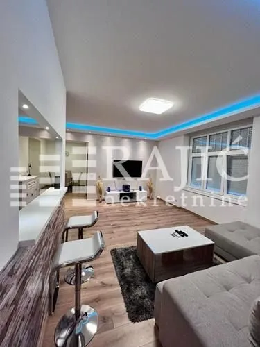 Living room with sofa, dining area, and bar counter.