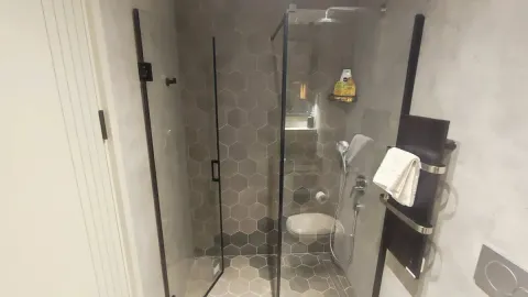 Modern bathroom with a shower cabin and hexagonal tiles. - image 9