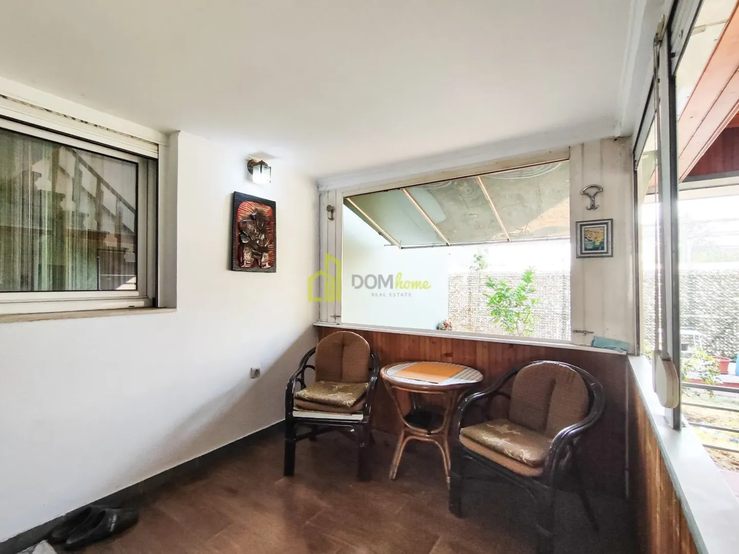 Enclosed balcony with seating furniture.