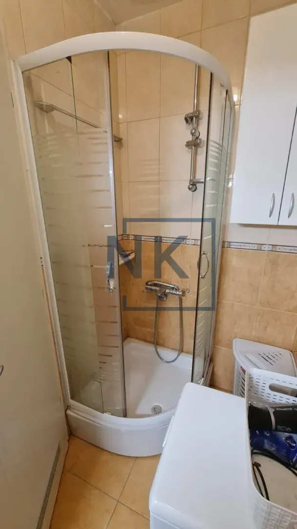 Bathroom with a shower cabin and beige tiles.