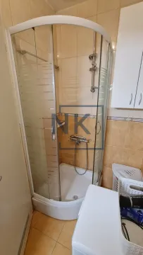 Bathroom with a shower cabin and beige tiles. - image 6