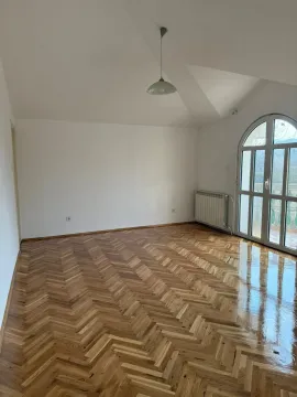 Empty room with parquet flooring and arched balcony doors. - image 16