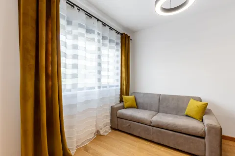 Dnevna soba sa sivom sofom, žutim jastucima i prozorom sa žutim i bijelim zavjesama. - image 14