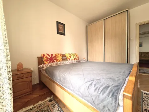 Bright bedroom with a double bed and a large built-in wardrobe. - image 6