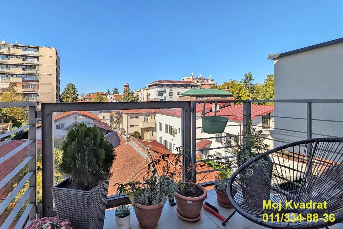 Furnished balcony with a view of the city and surrounding buildings.