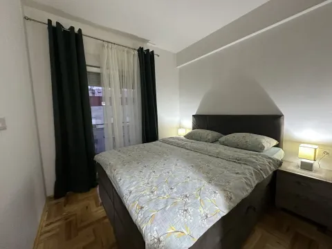 Opremljena spavaća soba sa bračnim krevetom, noćnim stočićima i prozorom sa zavjesama. - image 4