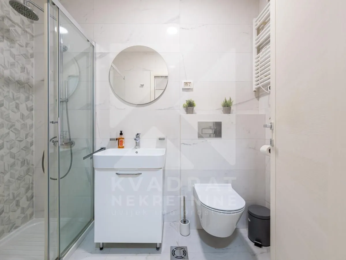 Moderne kupatilo sa tuš kabinom, umivaonikom i ugradnom wc šoljom.