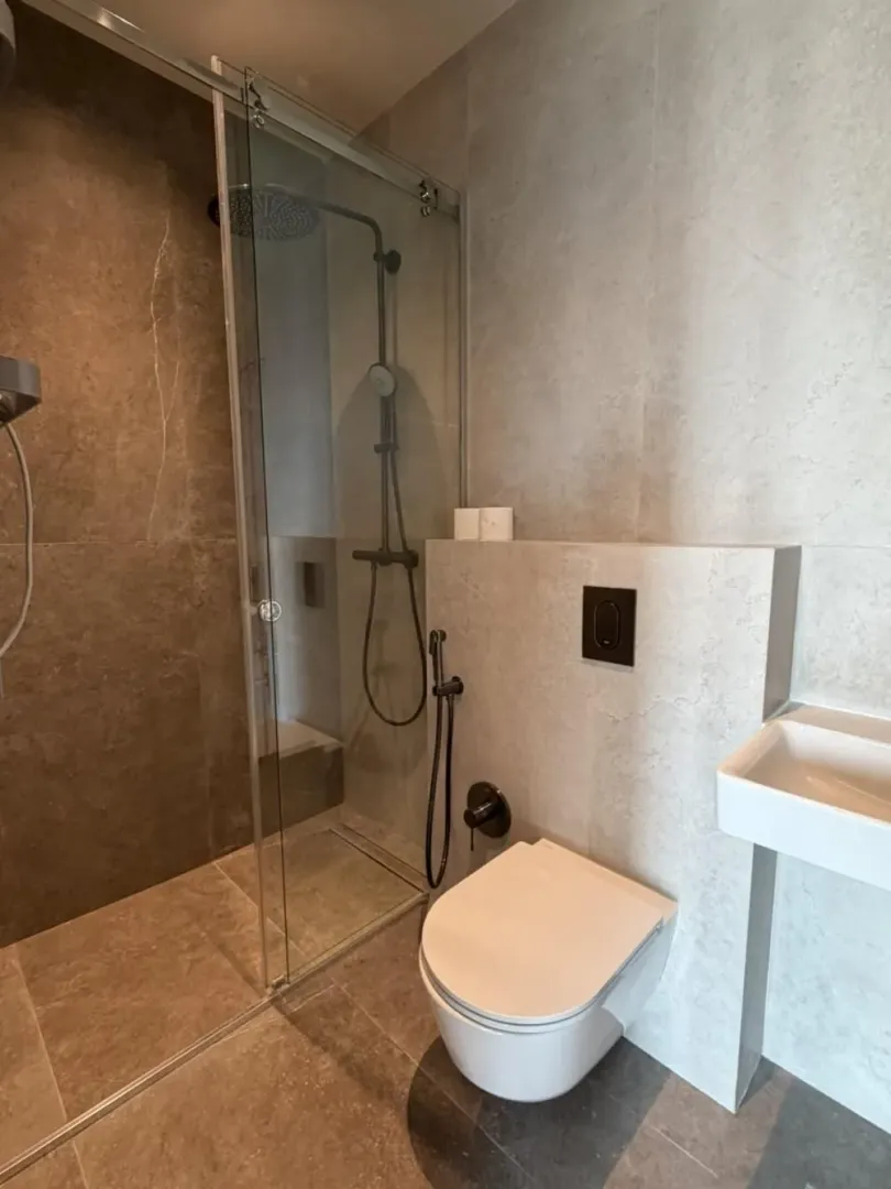 Savremeno opremljeno kupatilo sa tuš kabinom i ugradnom sanitarijom.
