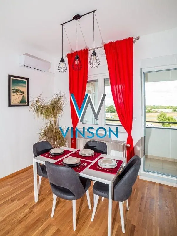 Dining area with a dining table and chairs, red curtains, and access to the balcony.