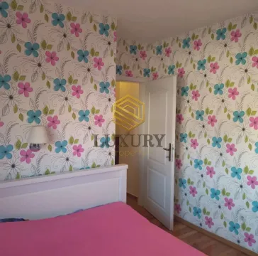 Bedroom with a bed and floral wallpaper on the walls. - image 2
