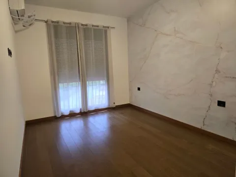Empty room with wooden flooring and a decorative accent wall. - image 4