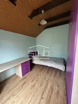 Manja spavaća soba sa krevetom, radnim stolom i ljubičastim ormarom pod kosim plafonom. - image 5