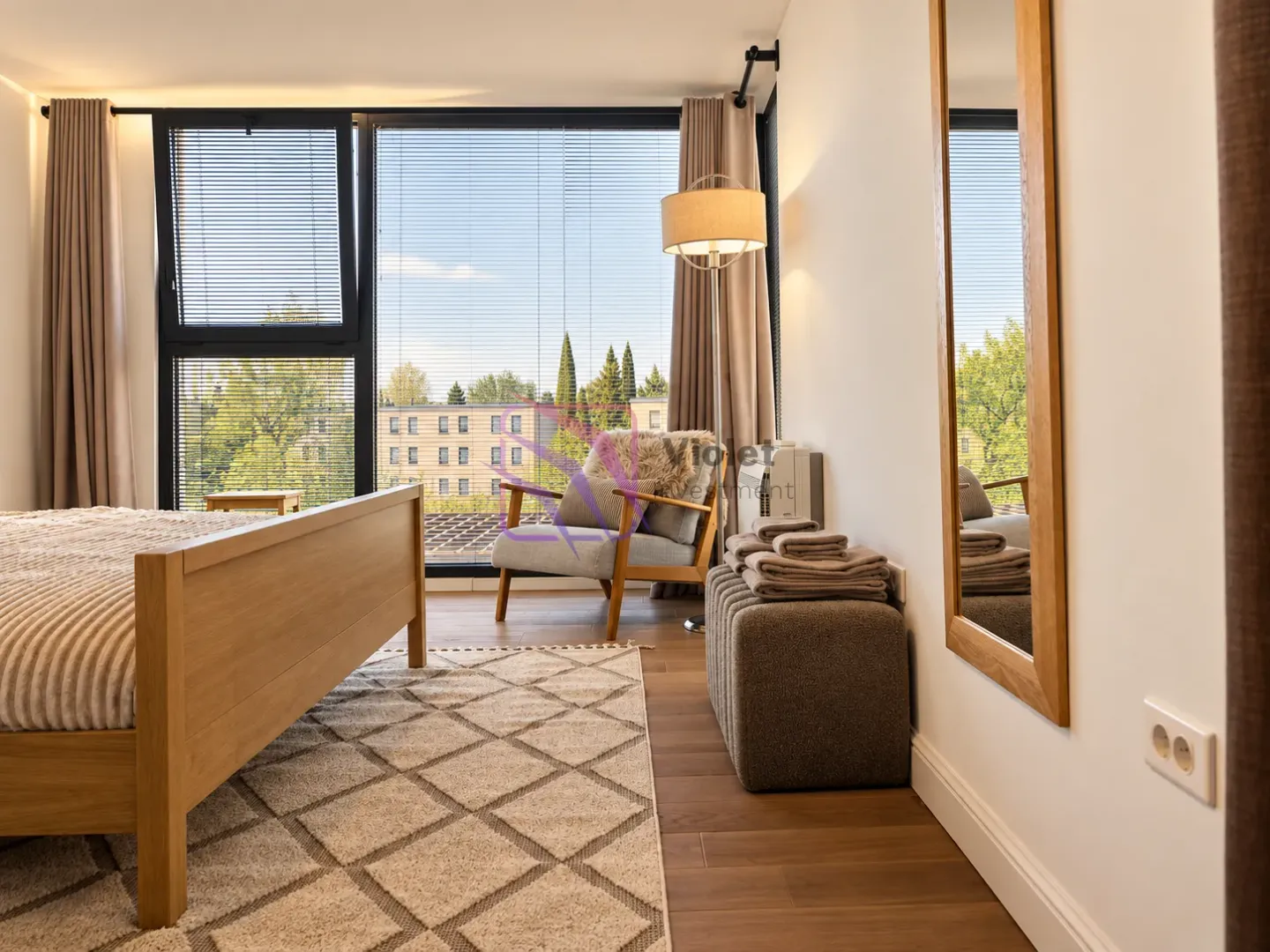 Modern bedroom with a double bed, armchair, and a large window.