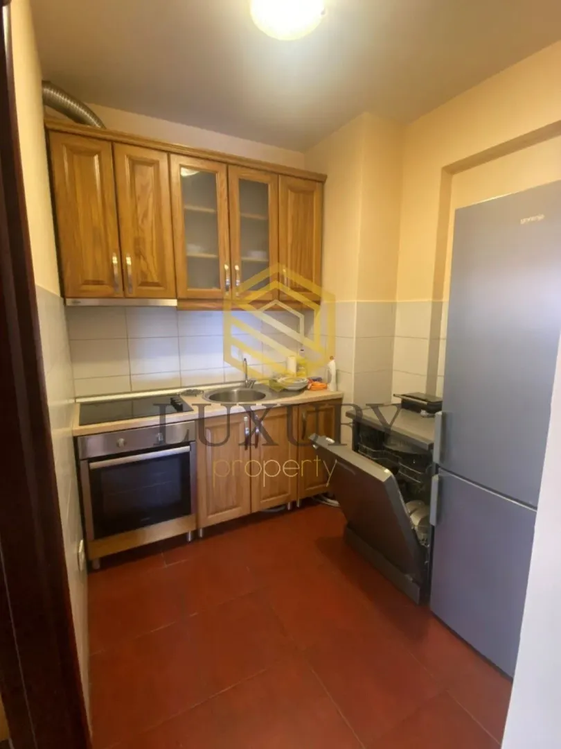 Small kitchen with wooden cabinets and appliances.