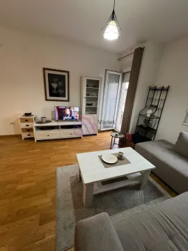 Dnevna soba opremljena garniturom, TV-om i bijelim komadima namještaja sa izlazom na terasu. - image 10