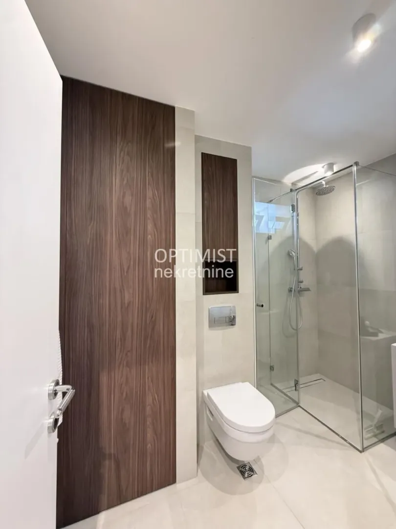 Modernly equipped bathroom with a walk-in shower and built-in sanitaryware.