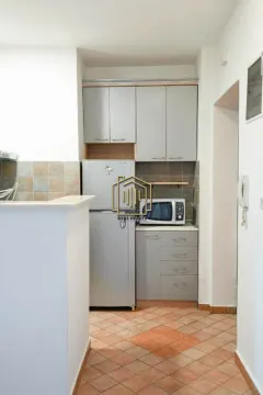 Small kitchen with grey cabinets and a refrigerator. - image 3