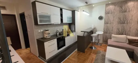 Moderna kuhinja sa šankom i trpezarijskim delom u sklopu dnevnog boravka. - image 5