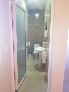 A simple restroom with a sink and a toilet. - image 8