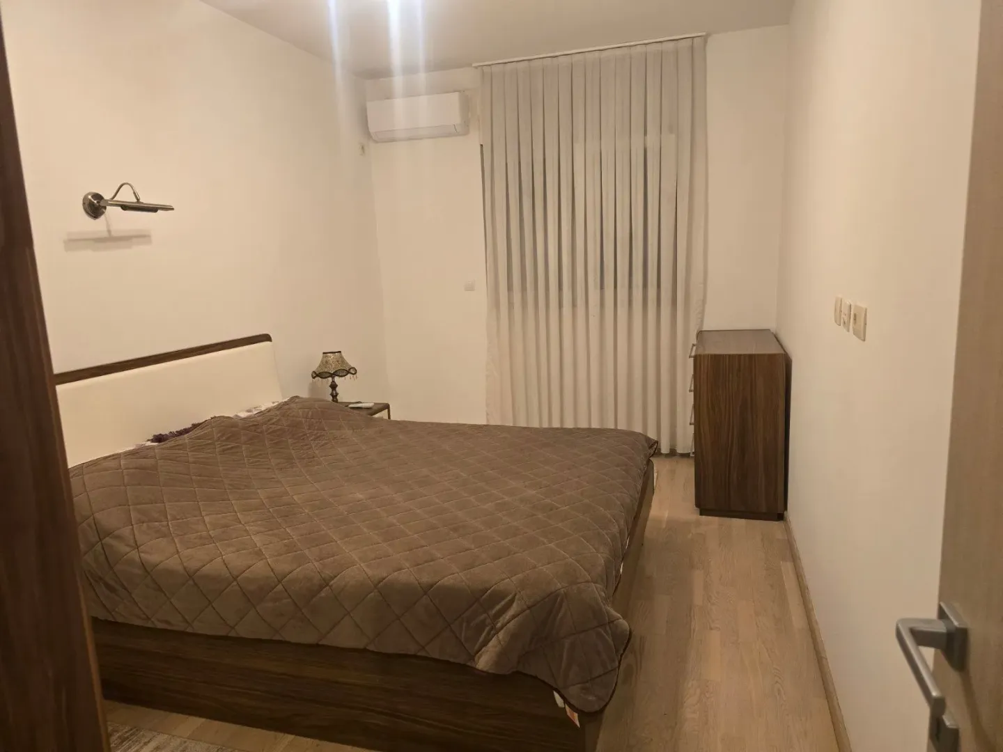 Namještena spavaća soba sa bračnim krevetom, garderoberom i klima uređajem.