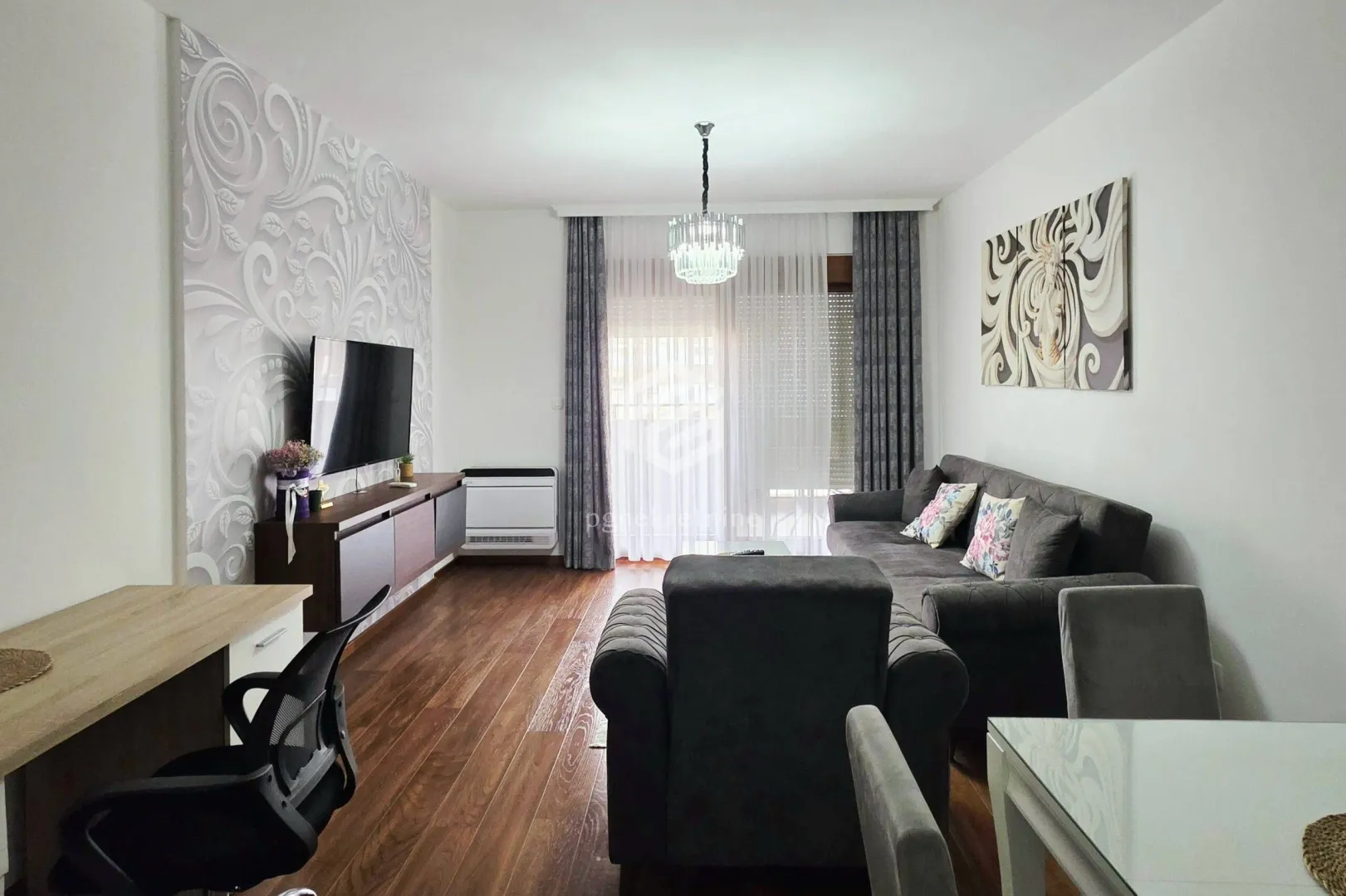Living room with a sofa, TV, and dining table.