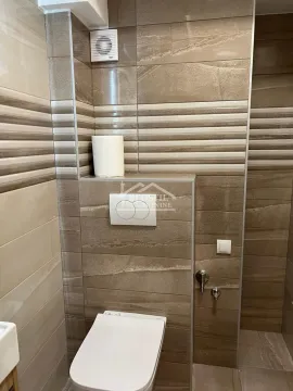 Pogled na kupatilo obloženo keramičkim pločicama u braon tonovima sa ugradnom šoljom. - image 7