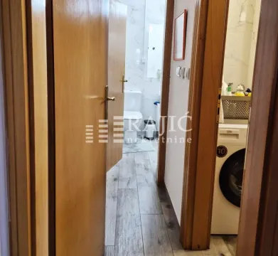 View of the bathroom through an open wooden entrance area. - image 12