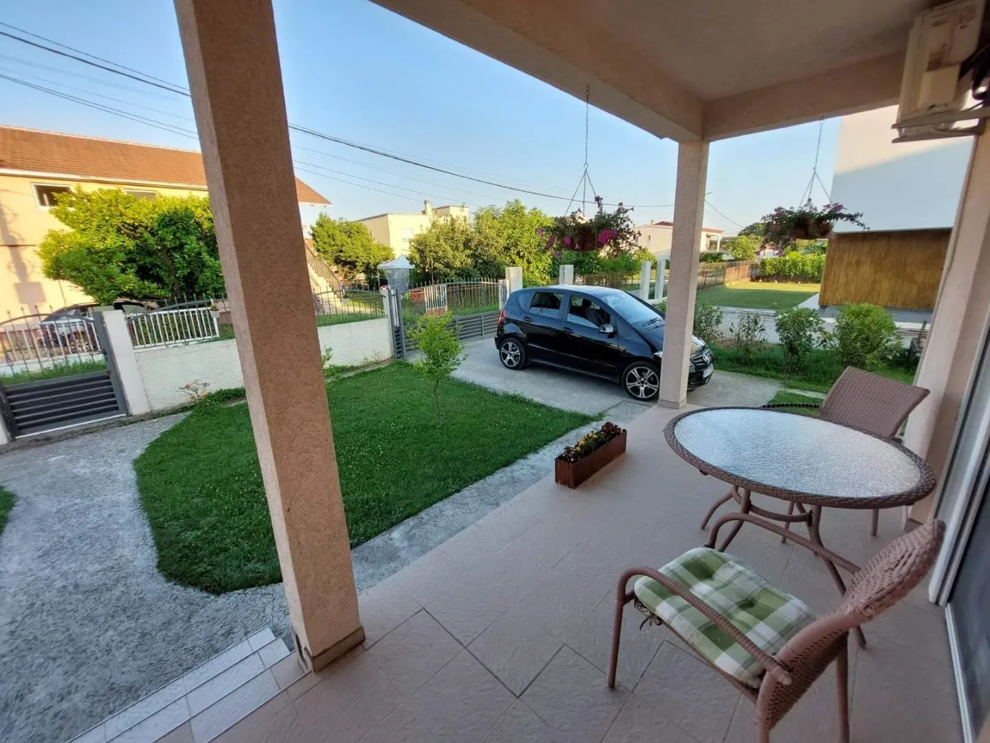 Covered terrace with seating area overlooking a landscaped yard.