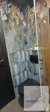 Modernly equipped bathroom with a dark toilet and decorative wallpaper with botanical motifs. - image 22
