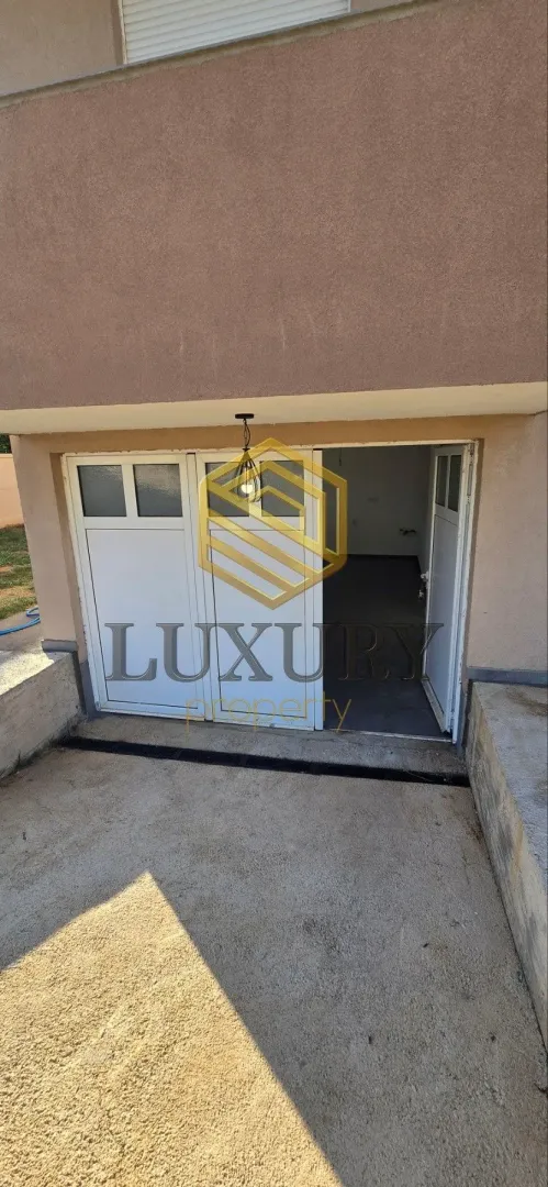 Garage entrance with open doors on the ground floor of the house.