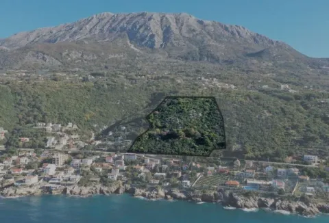 Vazdušni snimak terena sa označenom granicom parcele i pogledom na planinu i more. - image 4