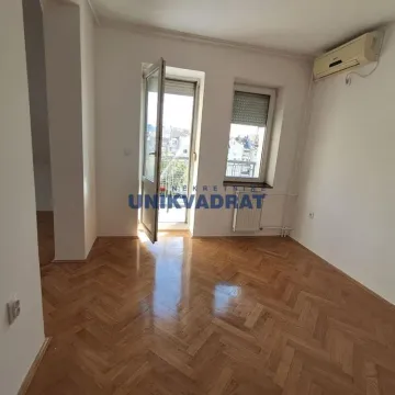 Prazna soba sa parketom na podu, klima uređajem i izlazom na balkon. - image 11