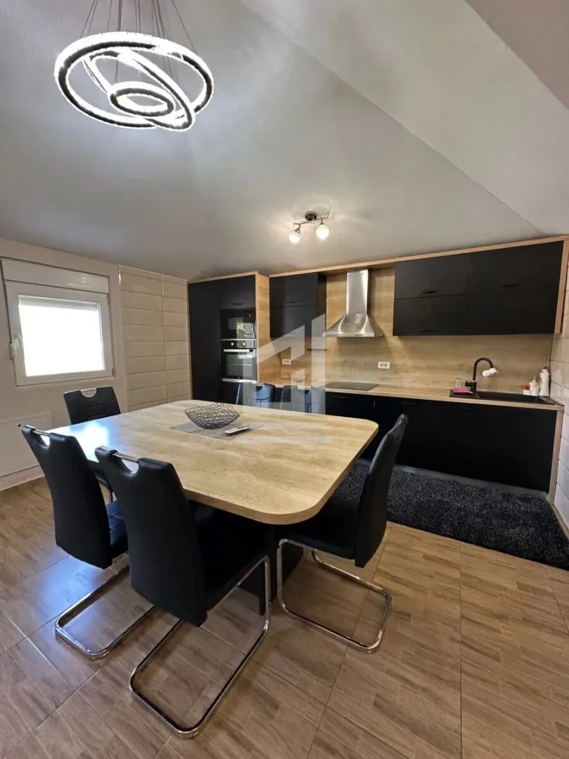 Modern kitchen with a dining table and black chairs.
