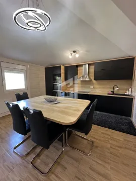 Modern kitchen with a dining table and black chairs. - image 3